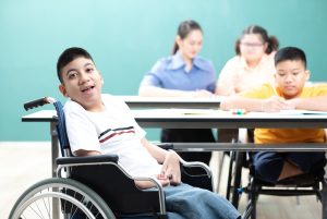 portrait asian disabled kids or autism child sitting on a wheelchair in classroom