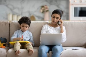 Parent sitting next to her young child on a couch applies for assistance