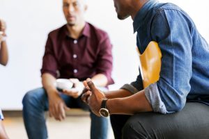 Group of men discuss mental health issues at a meeting