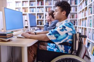 Boy with disability using computer in school