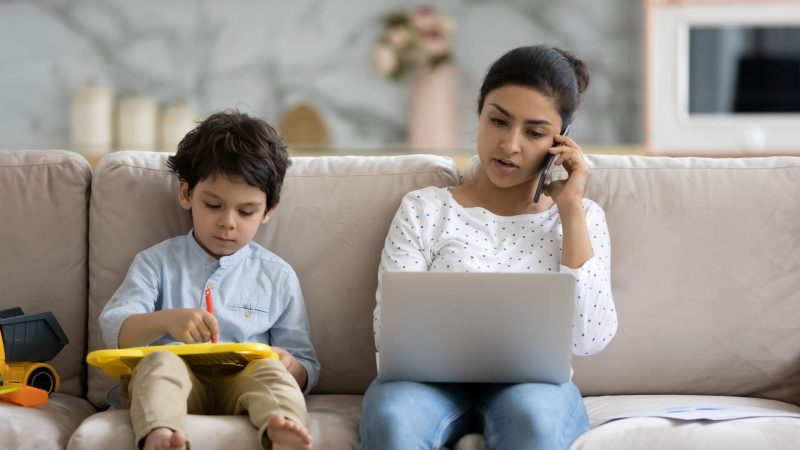 Apply for Help Parent sitting next to her young child on a couch applies for assistance