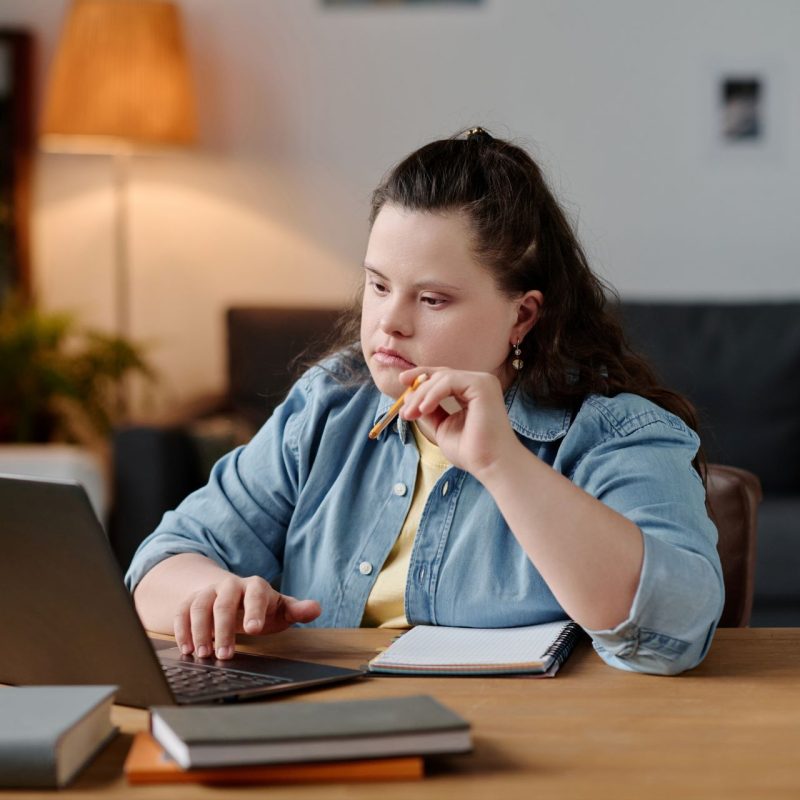 Woman with down syndrome working on her laptop.