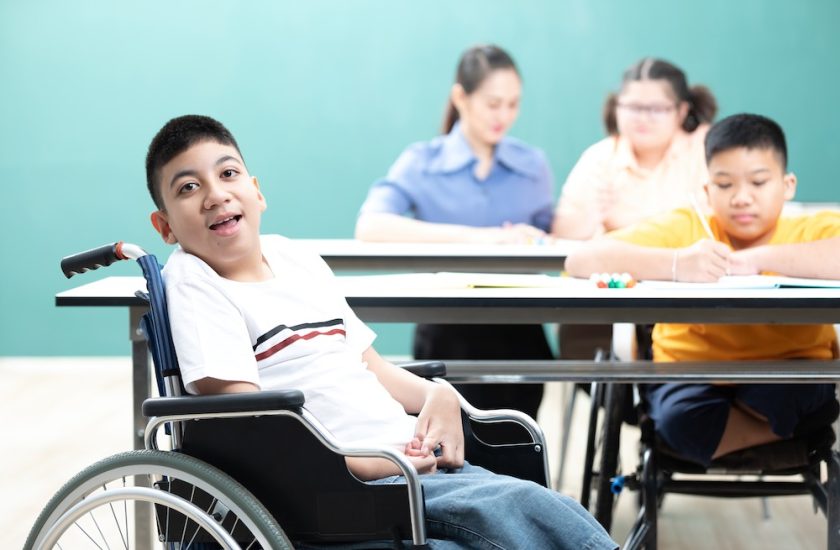 portrait asian disabled kids or autism child sitting on a wheelchair in classroom