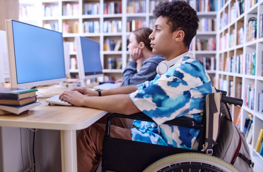 Boy with disability using computer in school